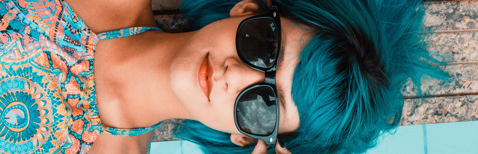 Jeune Femme aux cheveux bleus portant des lunettes de soleil